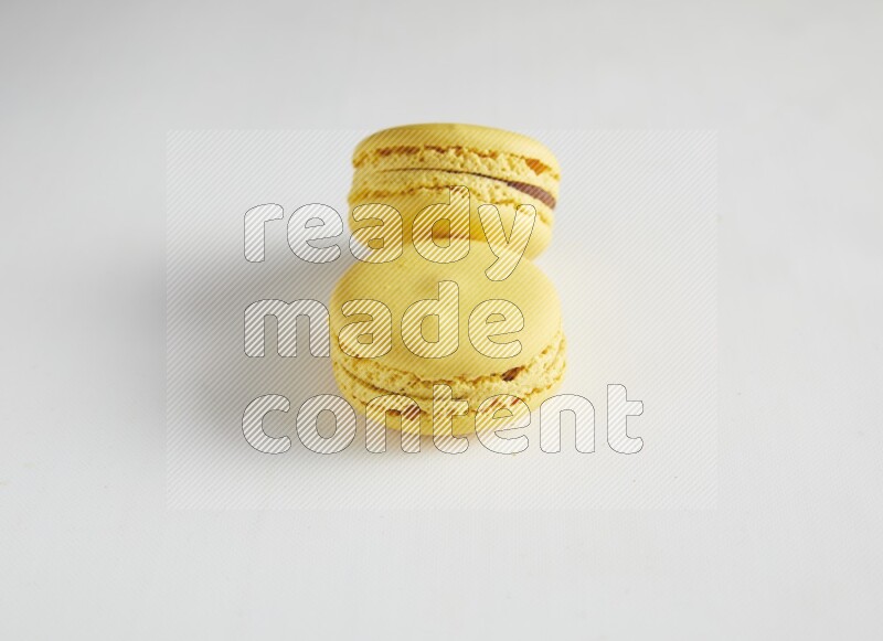 45º Shot of two Yellow Lemon macarons on white background