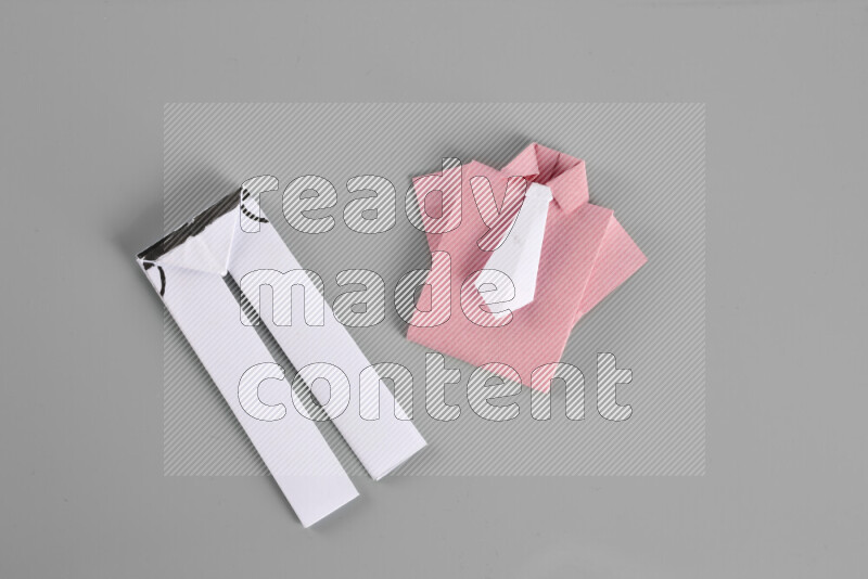 Origami clothes on grey background