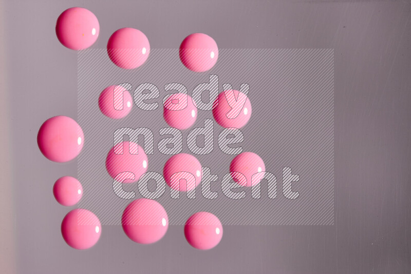 Close-ups of abstract pink paint droplets on the surface