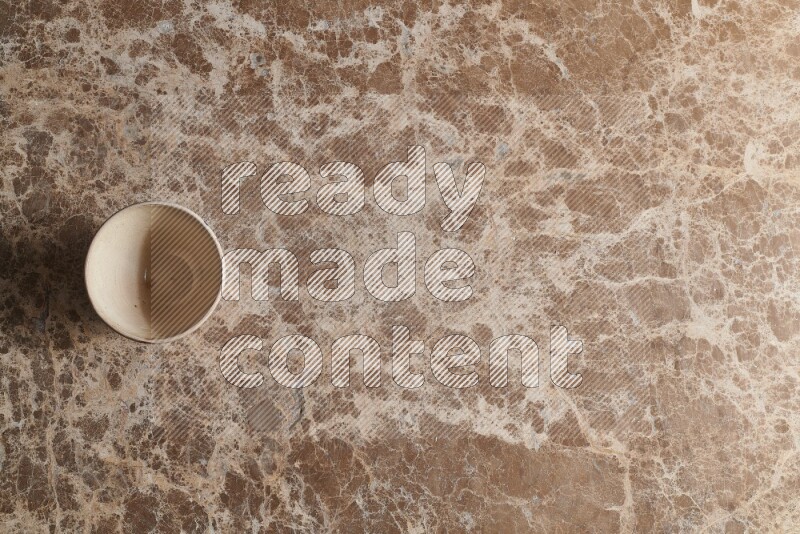 A white pottery bowl on beige marble background