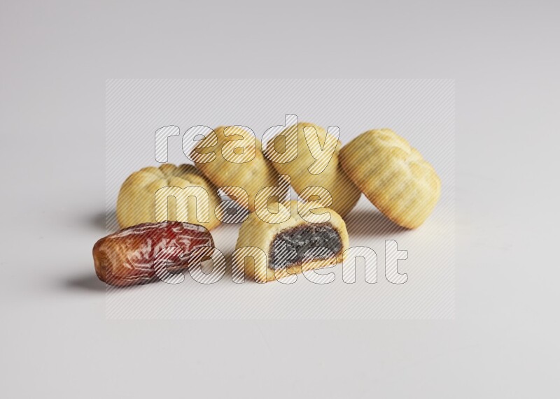Five Pieces of Maamoul filled with date one of them is cut direct on white background