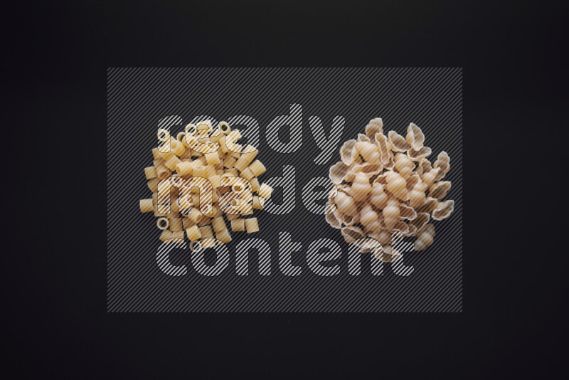 Different pasta types in bunches on black background