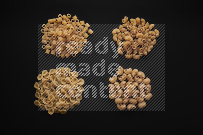Different pasta types in bunches on black background