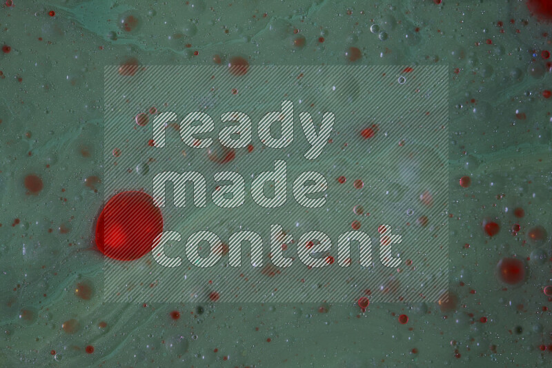 The image captures a dramatic splatter of red paint over a green backdrop