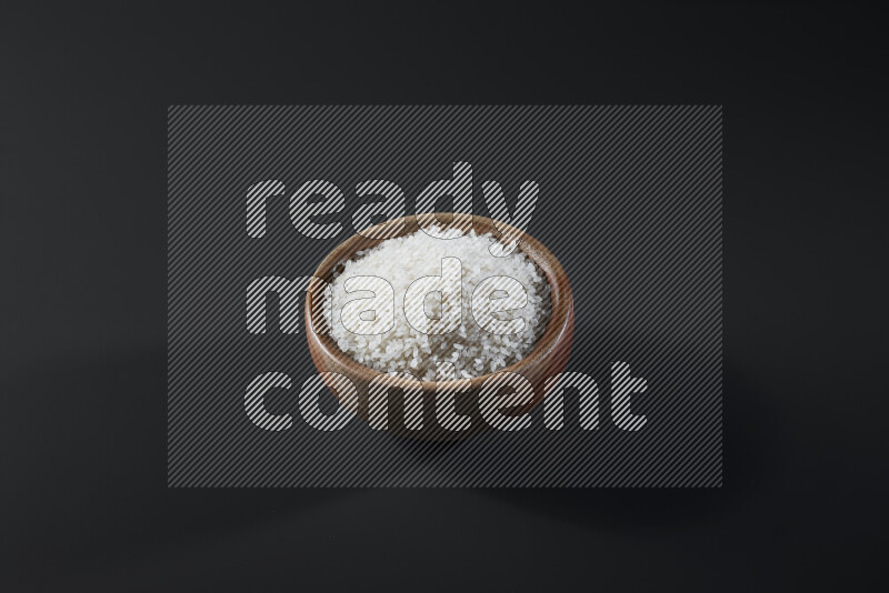 White rice in a wooden bowl on grey background