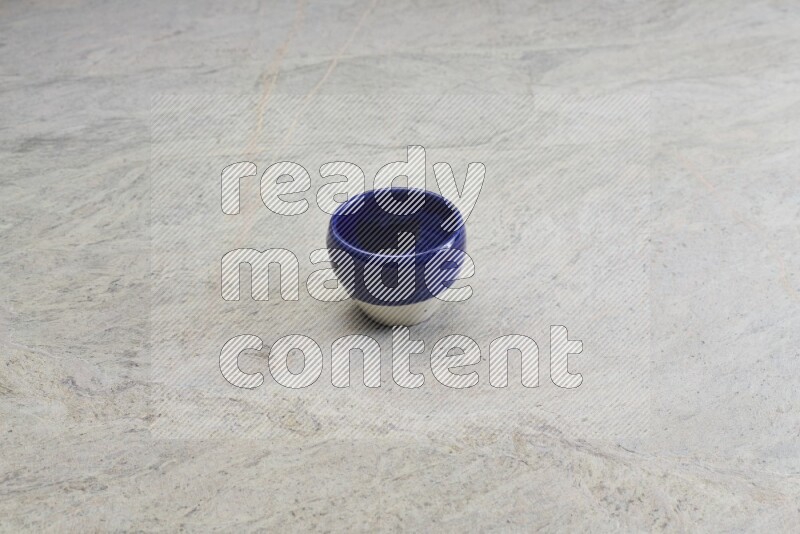 A multicolored pottery bowl on grey marble background