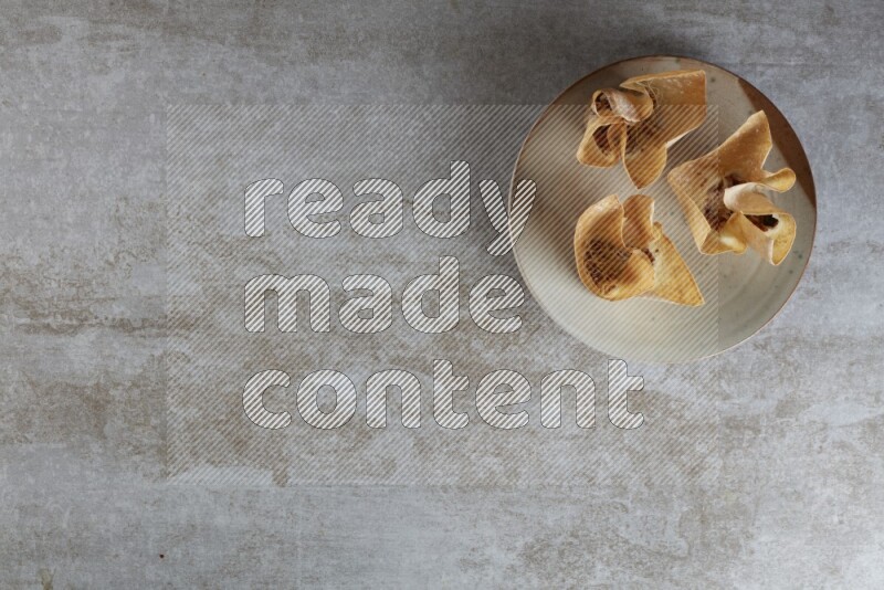 wonton cups with soy sauce ramkin on multi colored pottery on grey textured counter top