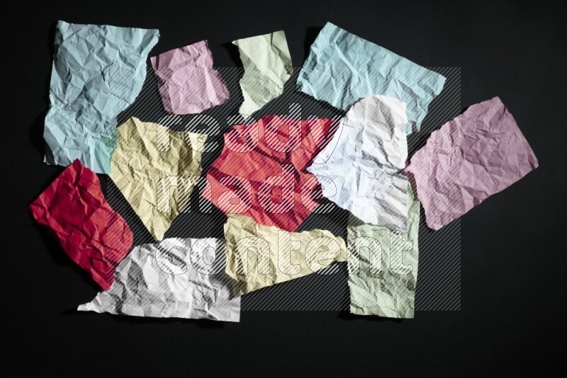 Crumpled multicolored paper on black background