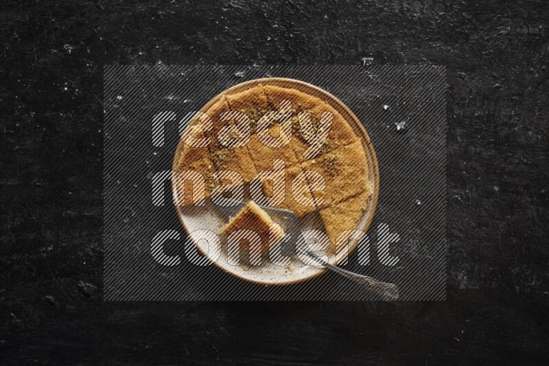 كنافة في أطباق مختلفه علي خلفية سوداء خشبية