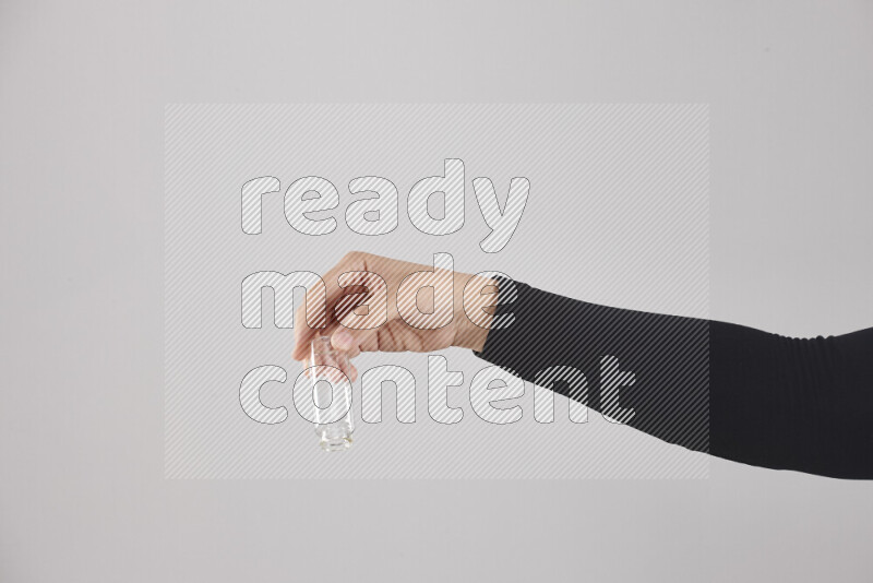 A woman in black abaya holding different glassware in different positions