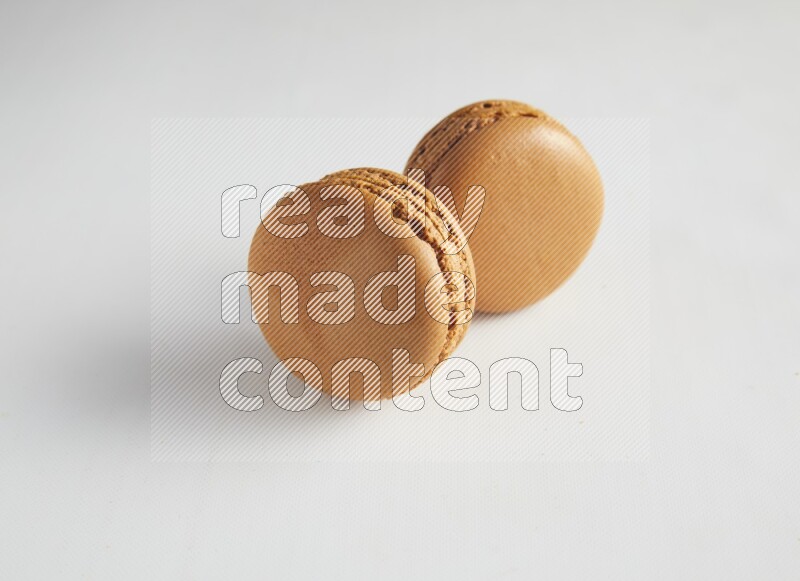 45º Shot of two Brown Maple Taffy macarons on white background