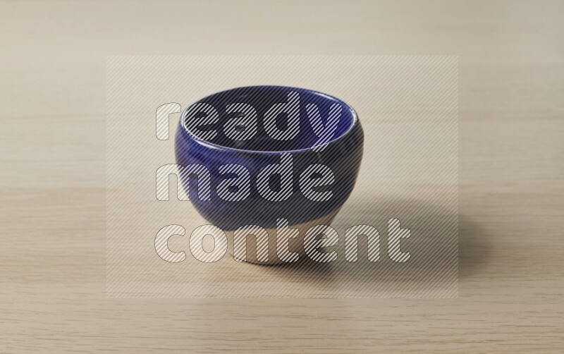 A multicolored pottery bowl on light wooden background
