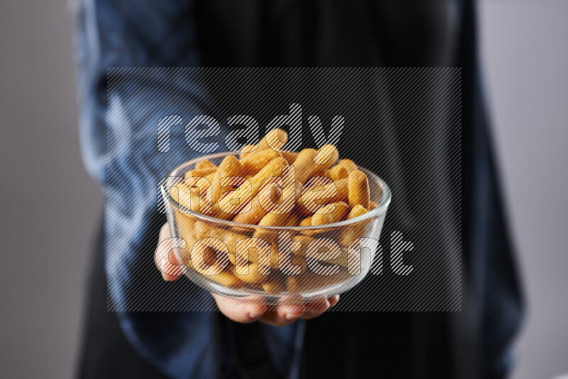 Woman in abaya holding different kinds of snacks in different positions