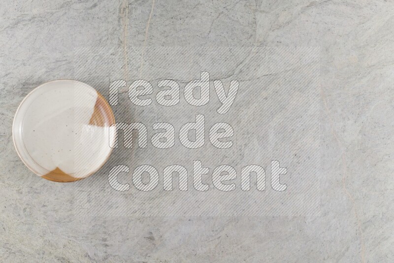 A decorative pottery plate on grey marble background