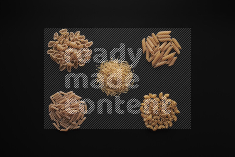 Different pasta types in bunches on black background