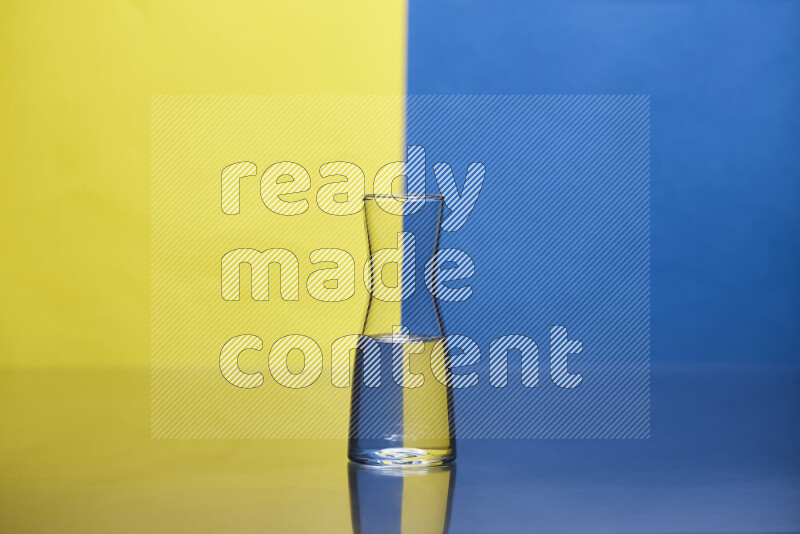 The image features a clear glassware filled with water, set against yellow and blue background