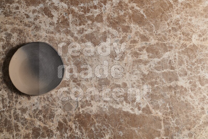 A multicolored pottery plate on beige marble background