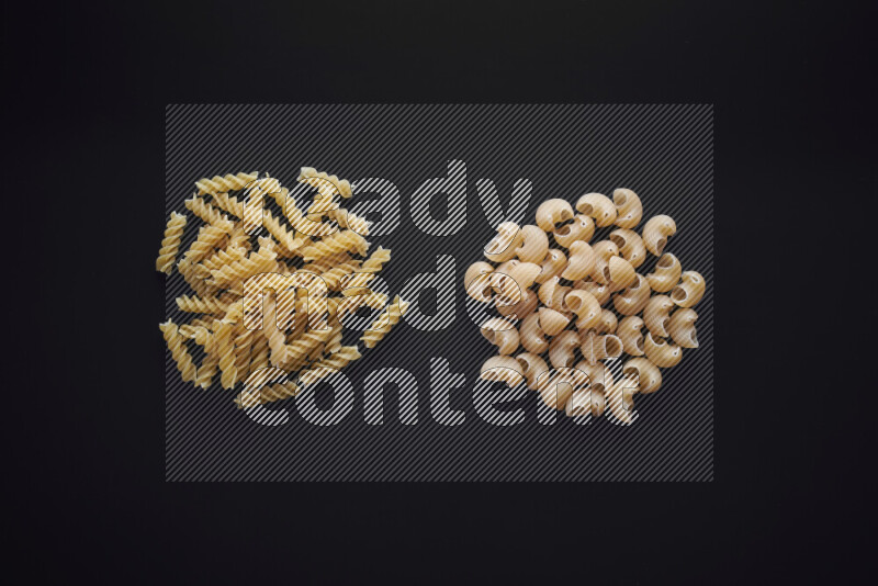 Different pasta types in bunches on black background