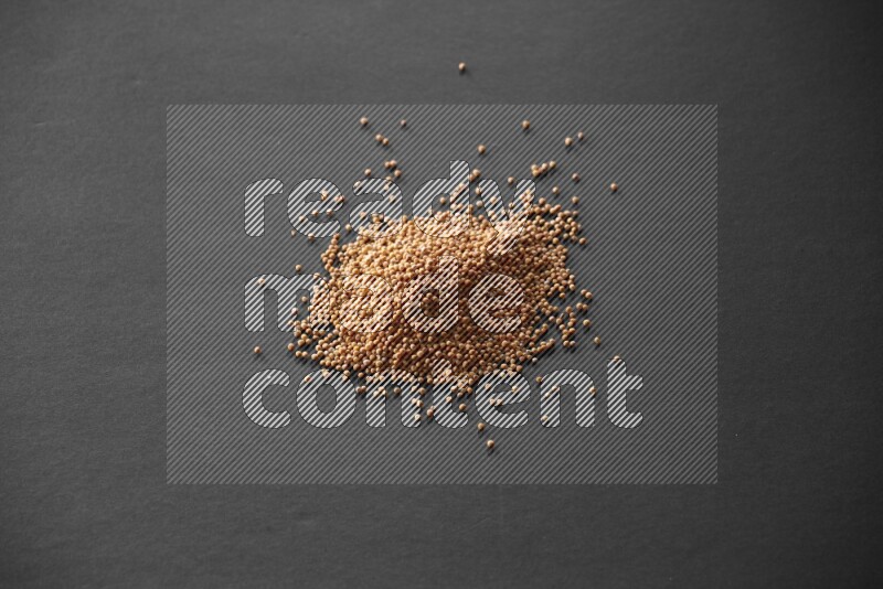 Mustard seeds on a black flooring