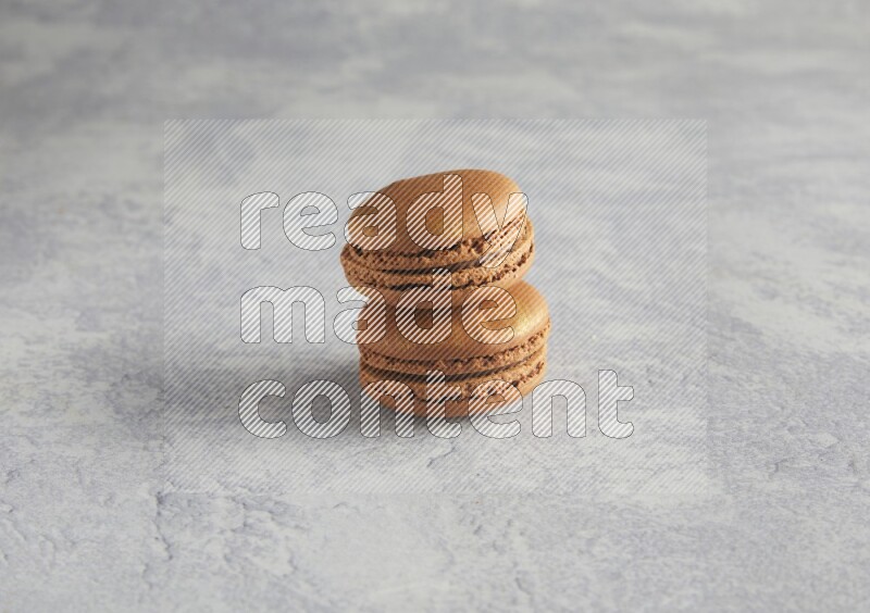 45º Shot of two Brown Coffee macarons  on white  marble background