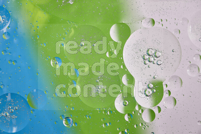 Close-ups of abstract oil bubbles on water surface in shades of white, green and blue