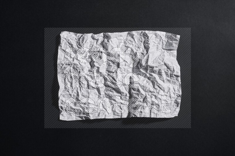 Crumpled notebook sheet on black background