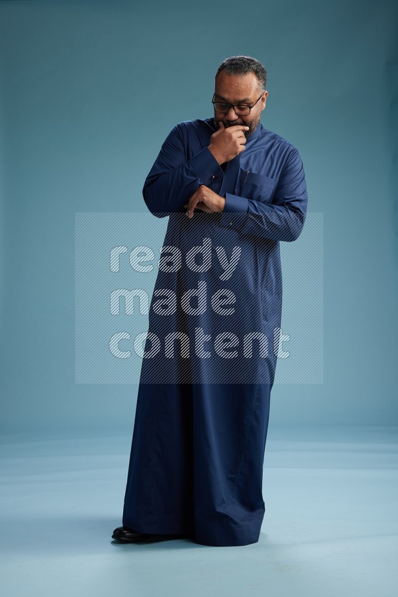 Saudi Man without shimag Standing Interacting with the camera on blue background