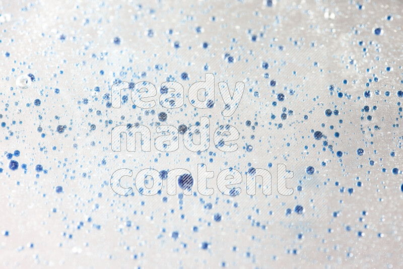Close-ups of abstract blue watercolor drops on oil Surface on white background