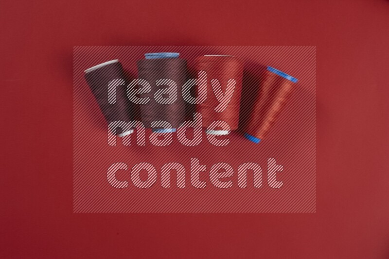 A red collection of sewing and tailoring tools arranged on a red background