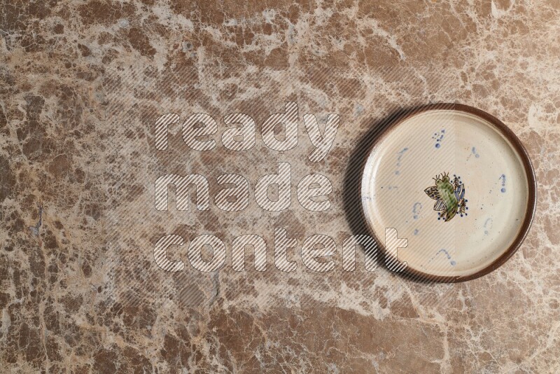 A decorative pottery plate on beige marble background
