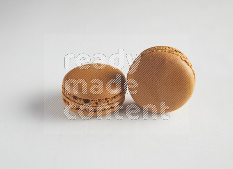 45º Shot of two Brown Maple Taffy macarons on white background