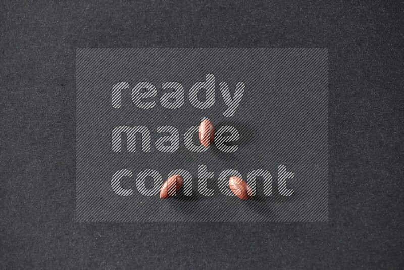 3 red skin peanuts on a black background in different angles