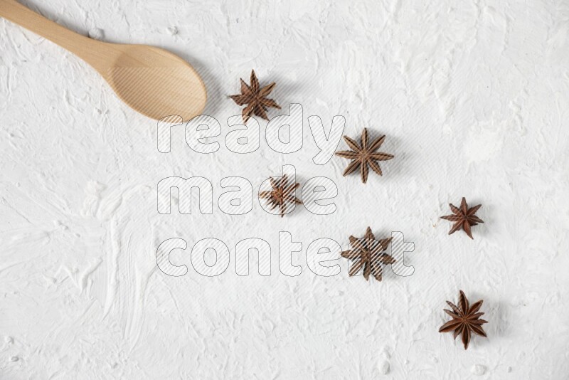 Star Anise in a wooden spoon on white flooring