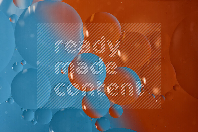 لقطات مقربة لفقاعات من الزيت على سطح الماء باللون الأزرق والبرتقالي