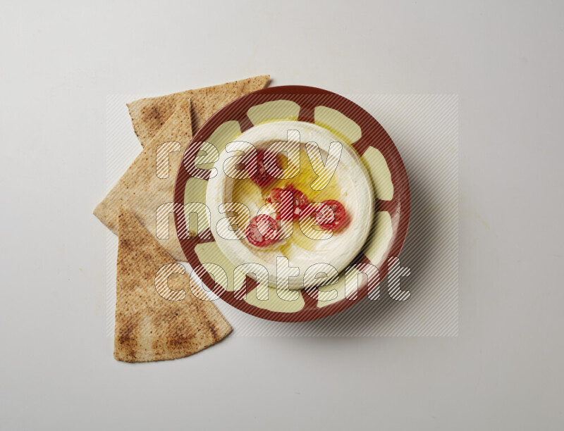 Lebnah garnished with Cherry tomato in a traditional plate on a white background