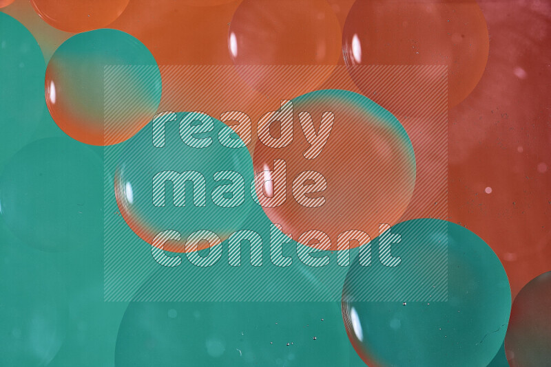 لقطات مقربة لفقاعات من الزيت على سطح الماء باللون الأخضر والبرتقالي