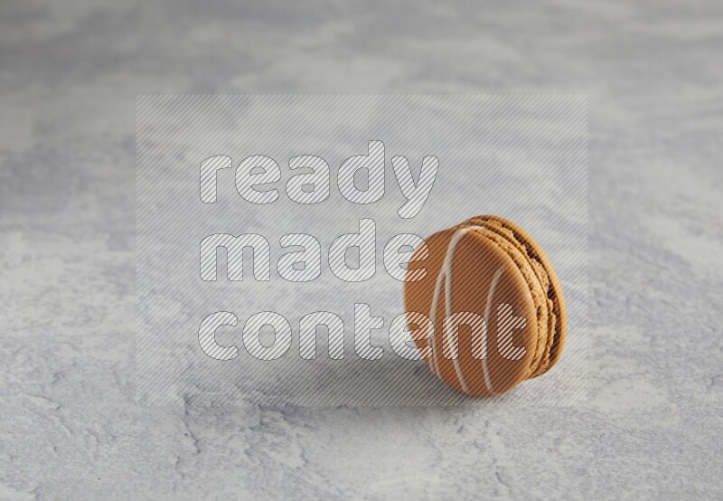 45º Shot of Brown Irish Cream macaron on white marble background