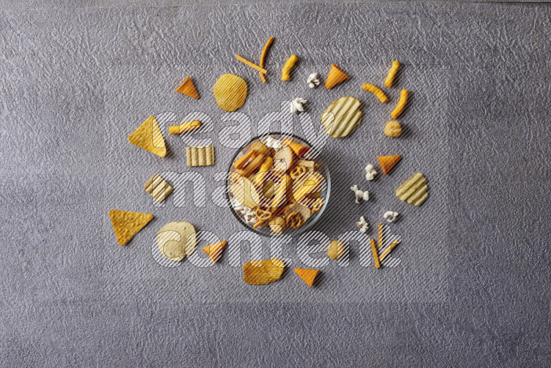 Assorted snacks in pottery bowls on grey background