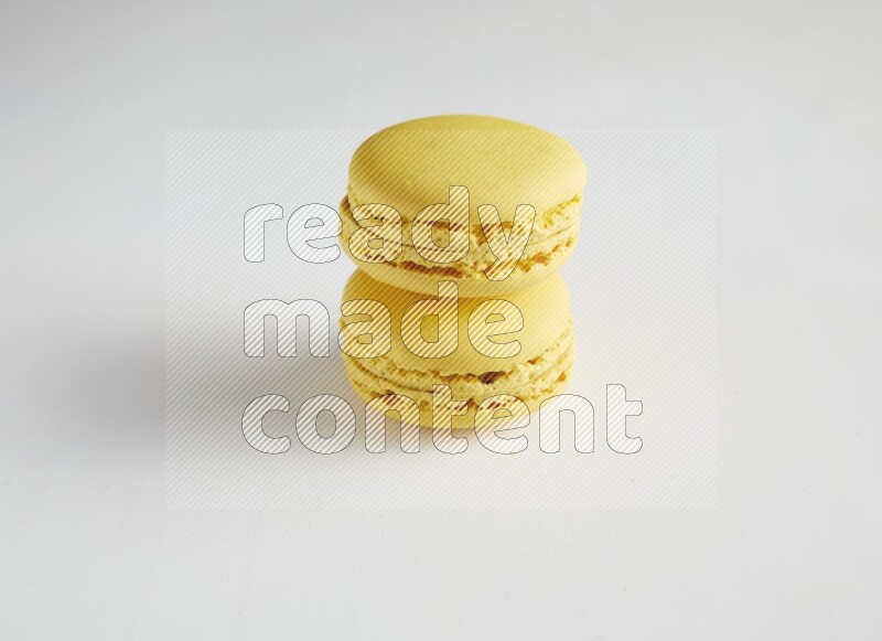 45º Shot of two Yellow Lemon macarons on white background