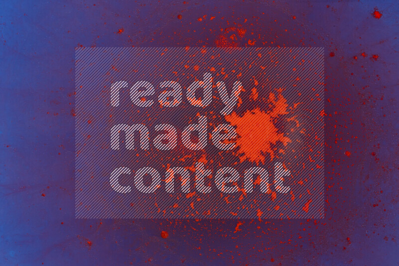 The image captures a dramatic splatter of red paint over a blue backdrop
