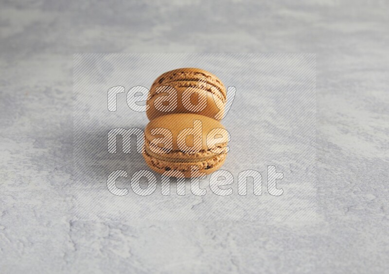 45º Shot of two Brown Maple Taffy macarons  on white  marble background