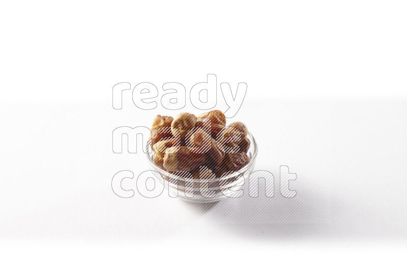Dates in a glass bowl on white background