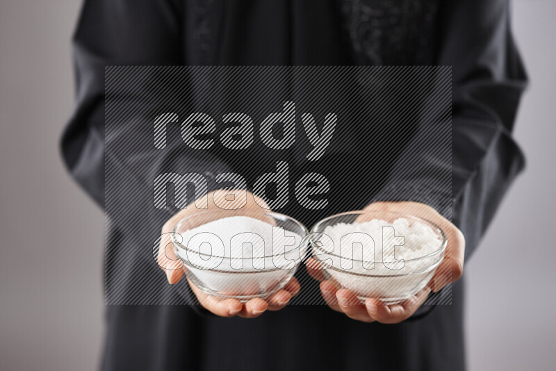 Woman in abaya holding different kinds of spices in different positions