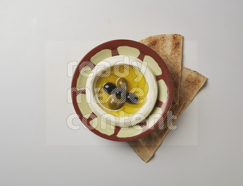 Lebnah garnished with olives in a traditional plate on a white background