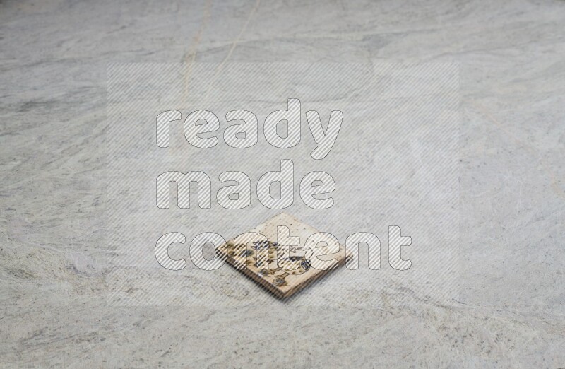 Top view shot of a pottery coaster\ tile on beige marble flooring