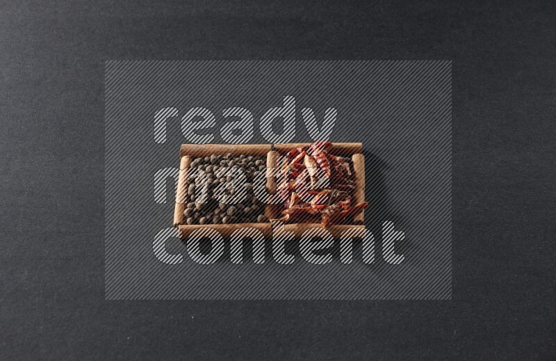 2 squares of cinnamon sticks full of chilis and allspice on black flooring