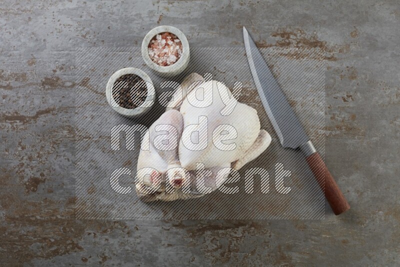 whole raw chicken  direct on a rustic grey background
