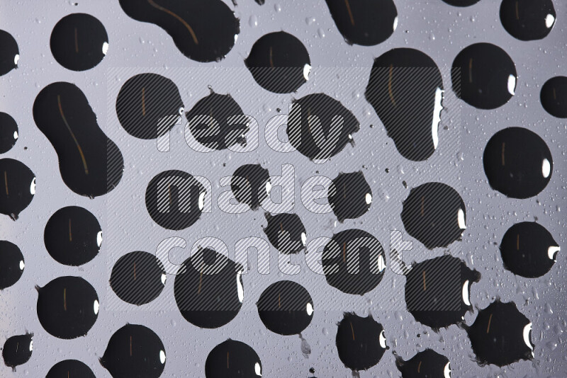 Close-ups of abstract black paint droplets on the surface