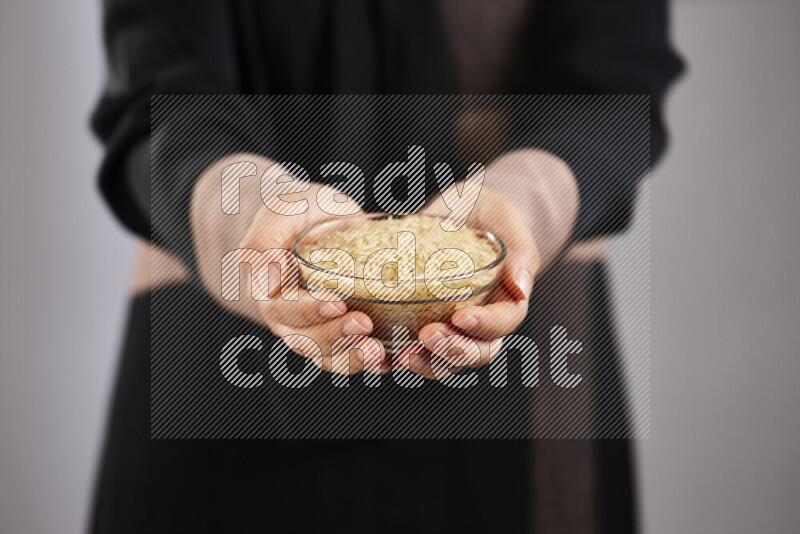 Woman in abaya holding different kinds of legumes in different positions