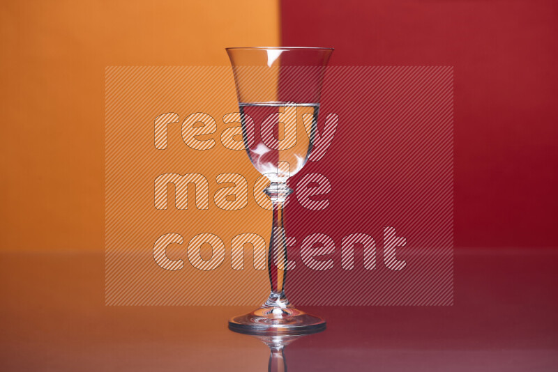 The image features a clear glassware filled with water, set against orange and red background